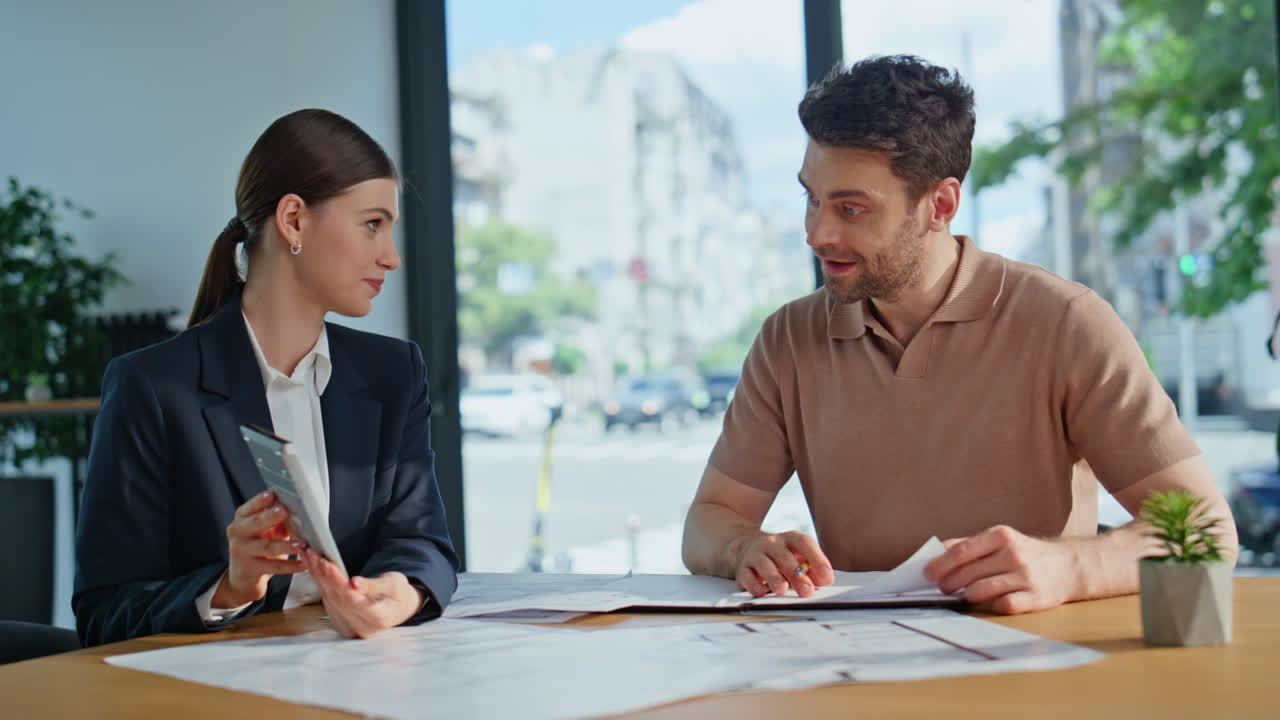 Financial manager negotiating client showing calculator at office desk closeup