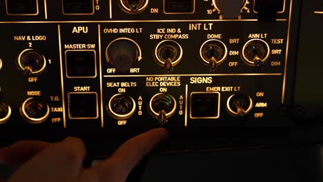 intricate view of airbus a320 flight deck, highlighting controls and instrumentation. pilot switching on the seat belts sign