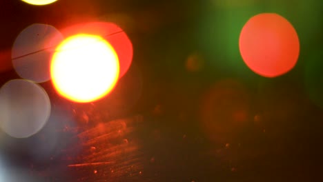 a blurred shot of car indicators, traffic lights and headlights taken from inside a car