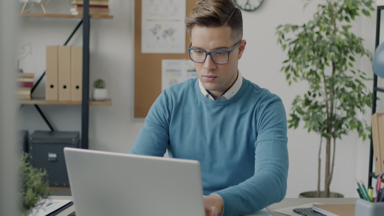 Hombre que trabaja en la computadora portátil en la oficina