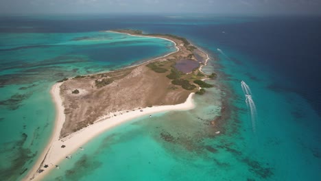 Cayo-de-agua-in-los-roques,-turquoise-waters-and-sandy-beaches-with-boats-speeding-by,-aerial-view