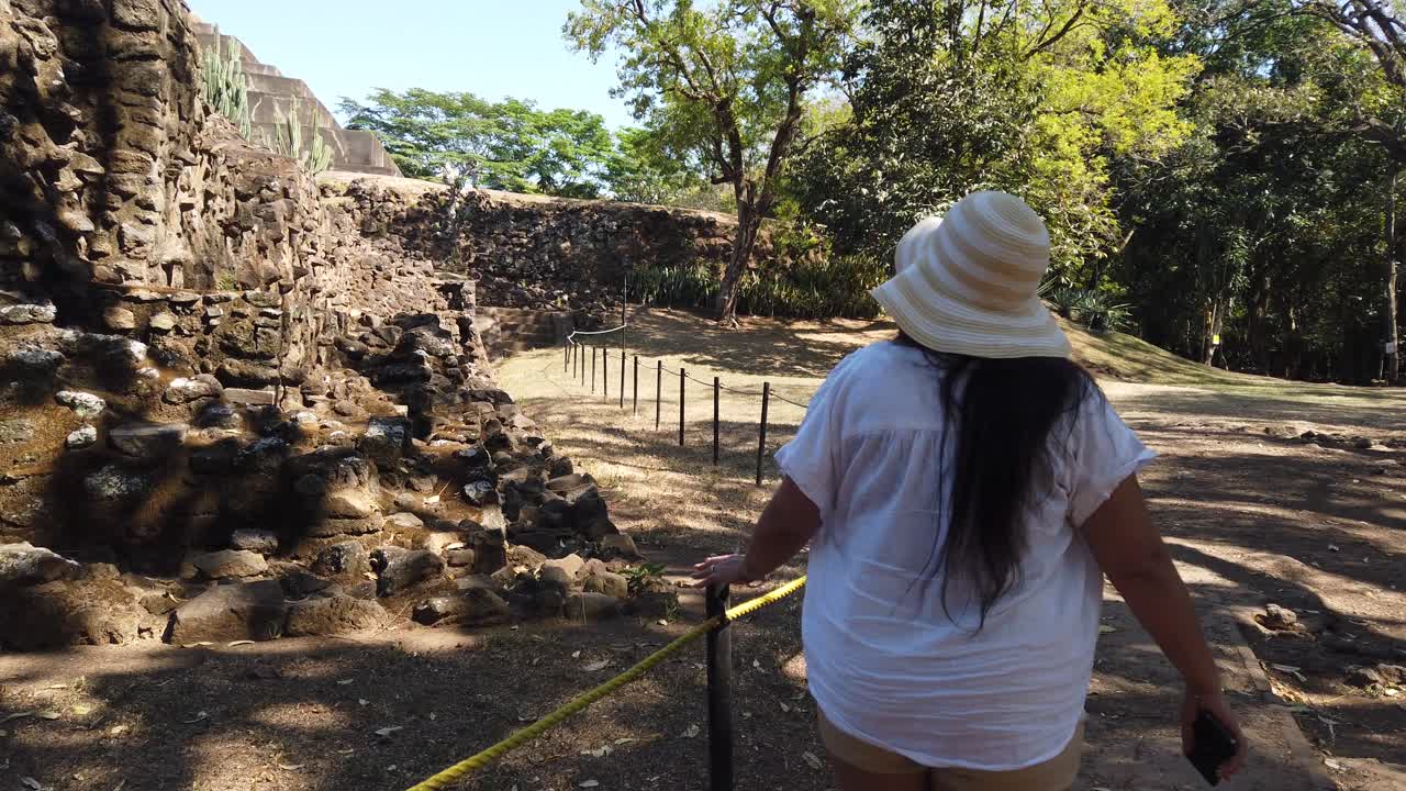 Donna turista che esplora un'antica piramide nelle rovine Maya di Tazumal, Santa Ana, El Salvador, Patrimonio Culturale.