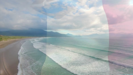 Digital-composition-of-waving-france-flag-against-aerial-view-of-the-beach