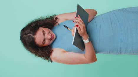 woman making notes writing down thoughts with pen into notepad notebook diary to do list good idea