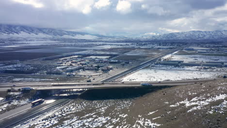 Flying-over-Highway-58-on-a-wintery,-snowy-day-in-Tehachapi,-CA