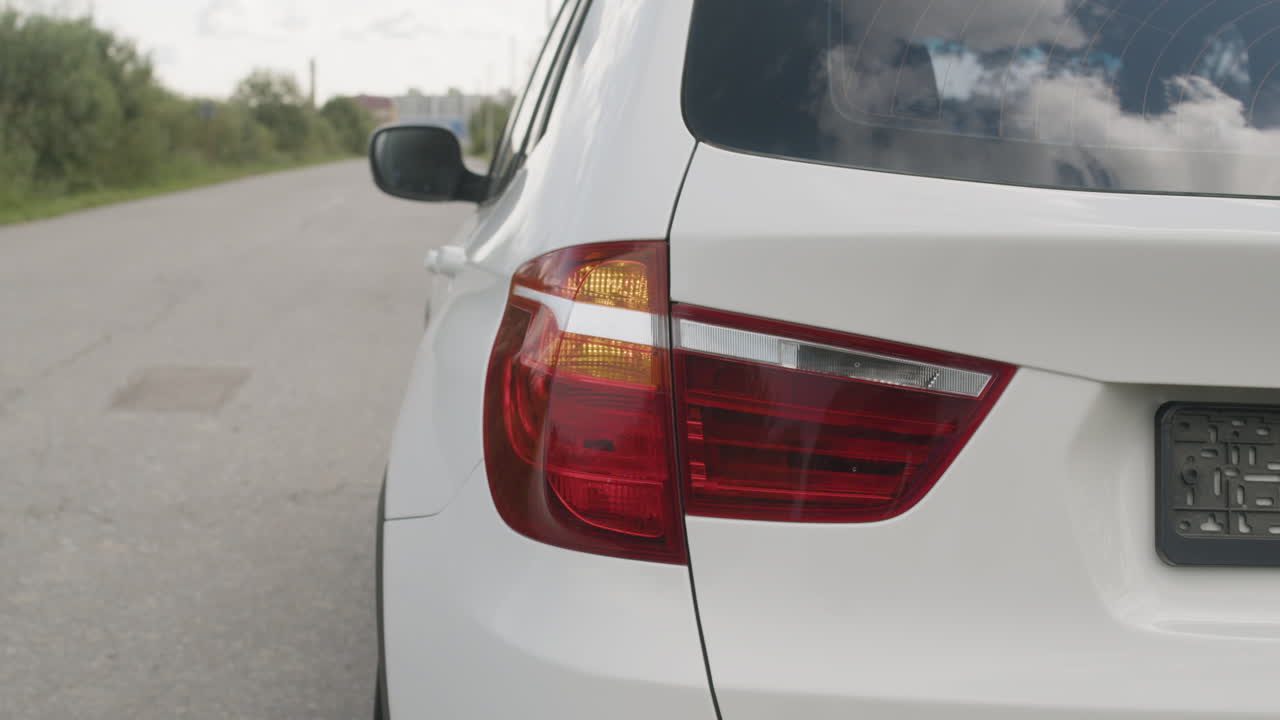 Close-up of a white car's tail light on a road