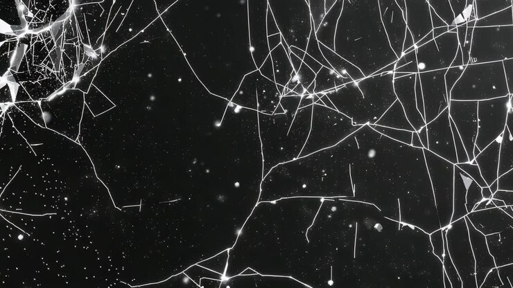 Cracking glass pane sending fissures from top-left crack across close-up, particles drifting