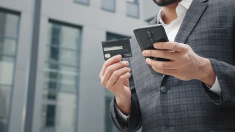 empresario que utiliza teléfono móvil y tarjeta de crédito