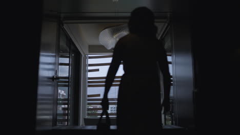 호텔에서 가방을 들고 걸어가는 여성의 낮은 실루엣 샷