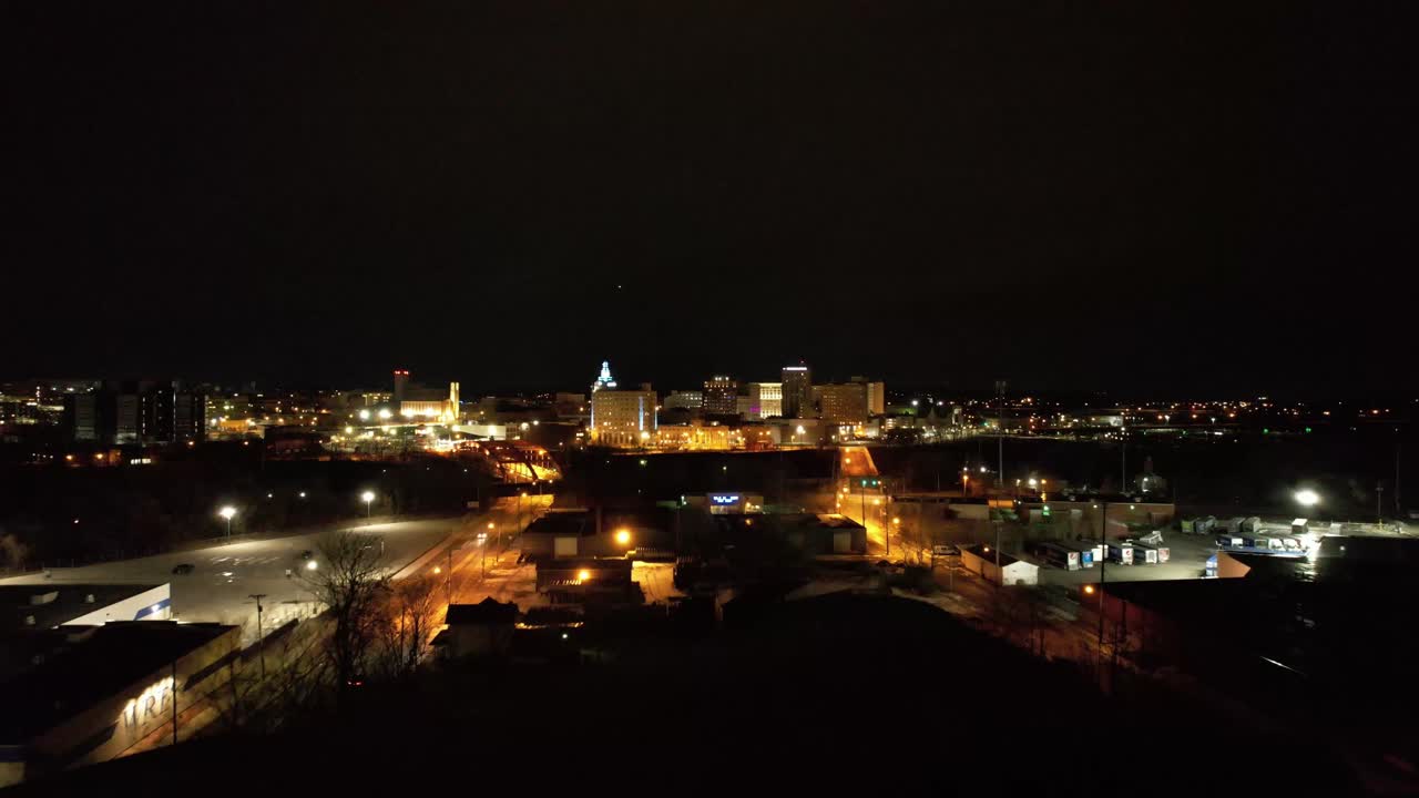 A drone captures the glowing lights of downtown Youngstown, Ohio at night, showcasing the city’s skyline and urban layout under dark skies.