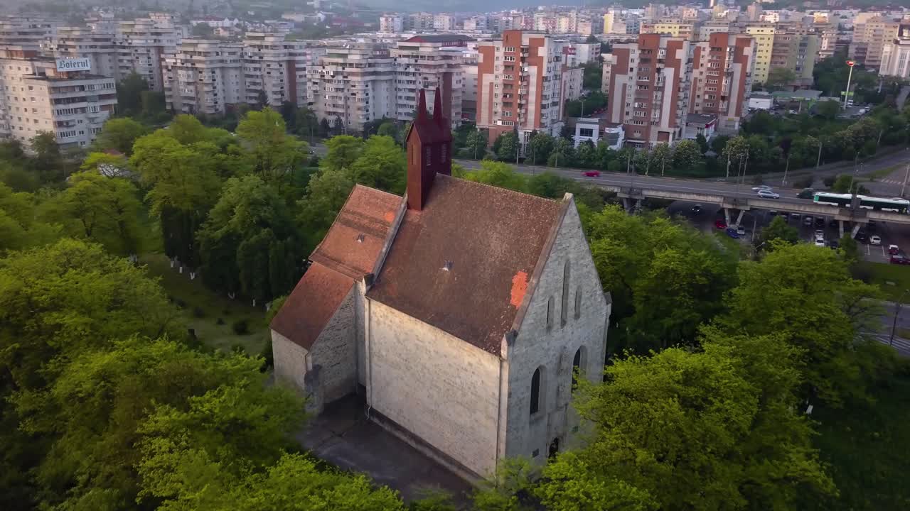 vista redonda de la hermosa iglesia entre el bosque de árboles y la vista de la ciudad monumento cluj, rumania, transilvania