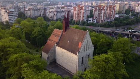 round view of beautiful church between trees forest and view of monument town cluj, romania, transylvania