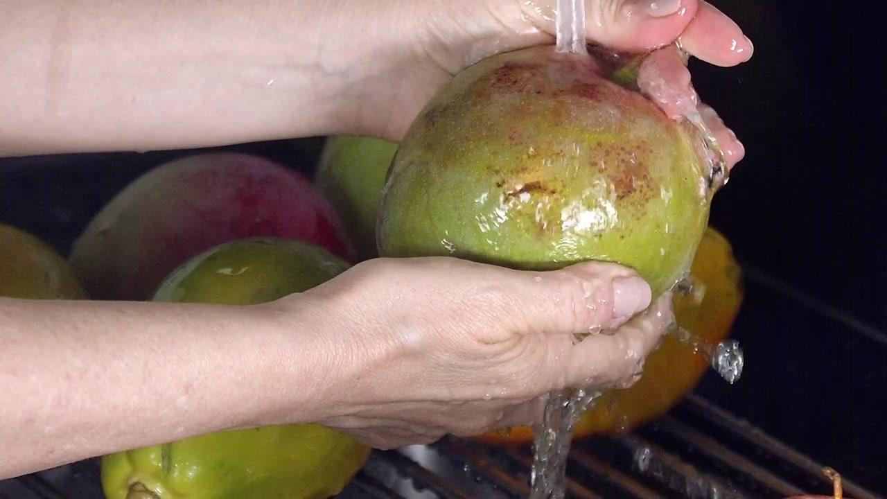 Per pulire un mango, fresco e dolce, sciacqualo bene, una deliziosa prelibatezza.