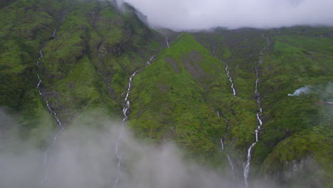 Vista-Aérea-Del-Paisaje-Salvaje-Con-Cascadas-Cubiertas-Por-Nubes-Y-Colinas-Verdes-Celestiales-De-Nepal-4k