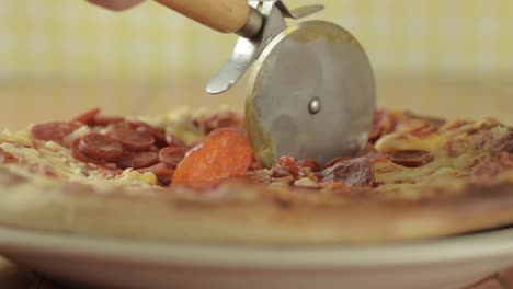 Cutting-pepperoni-pizza-with-pizza-wheel-medium-shot