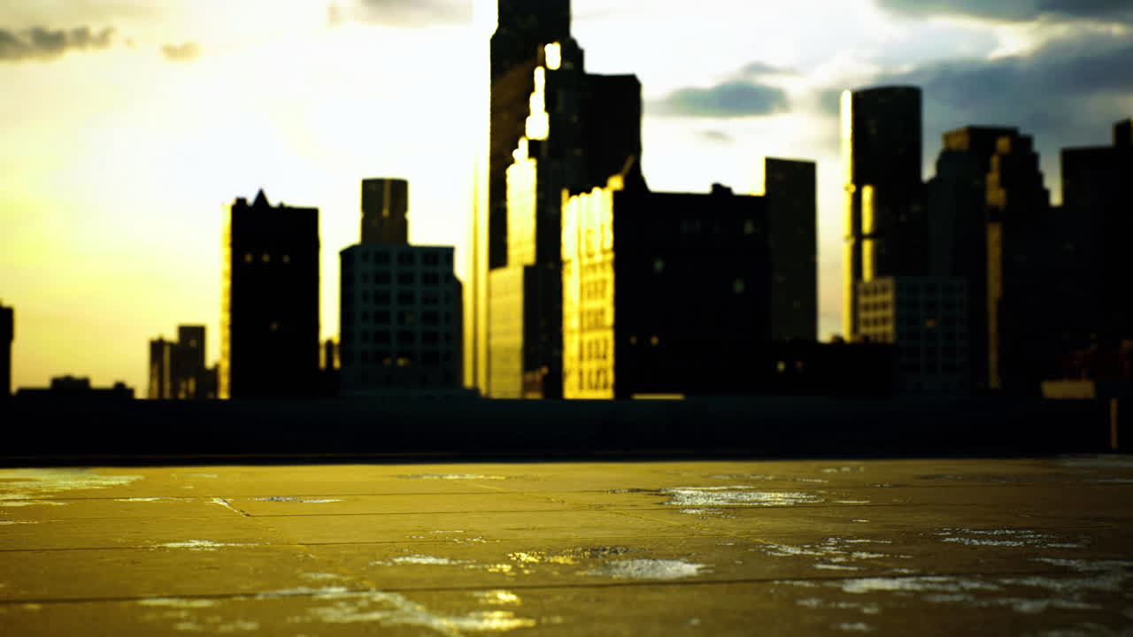 City skyline reflecting golden light during sunset on a wet rooftop