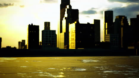 city skyline reflecting golden light during sunset on a wet rooftop