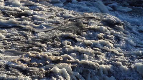 water seeps between blocks of ice on a river in iceland