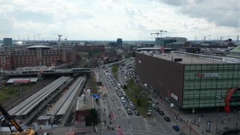 Forwards-fly-above-busy-streets-in-city-near-Hamburg-Hauptbahnhof-train-station.-Tilt-down-shot-of-intersection-in-rush-hour.-Free-and-Hanseatic-City-of-Hamburg,-Germany