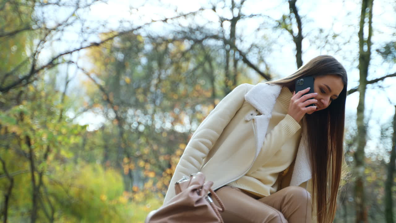 Woman Talking on Phone in Autumn Park