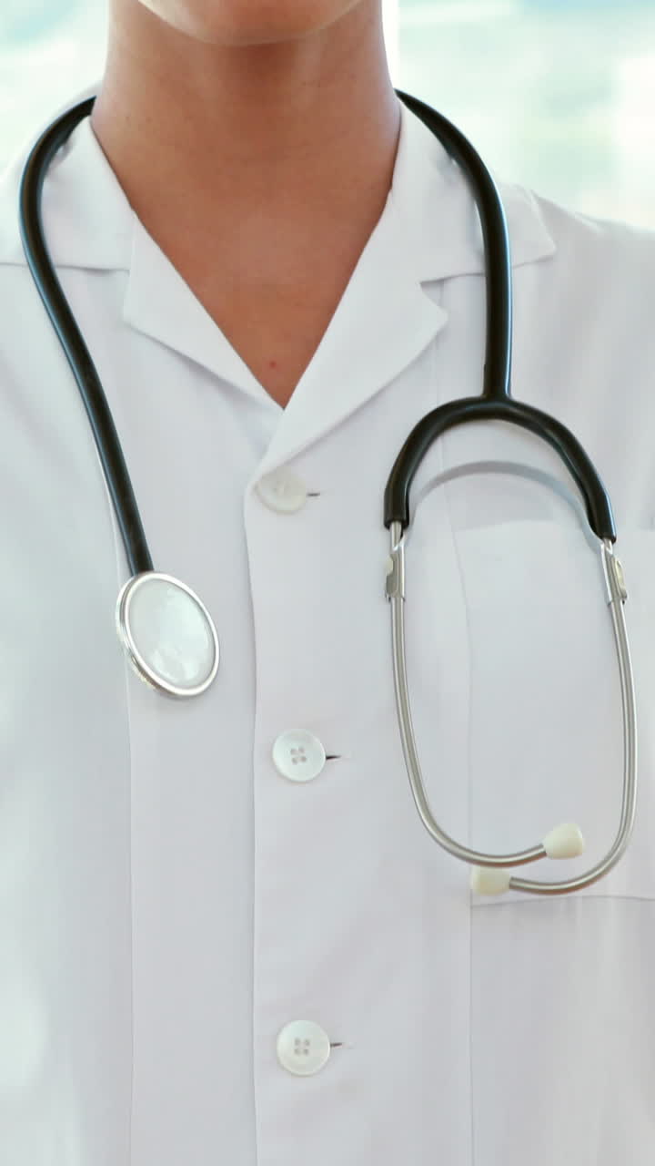 dottore felice che guarda la telecamera con le mani in tasca