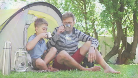 animación de puntos de luz sobre padre y hijo caucásicos bebiendo té en una tienda de campaña en el jardín