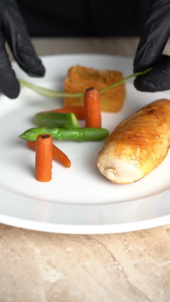 Chief plating roasted chicken piece with carrots and green beans on a plate, close up shot, insert shot