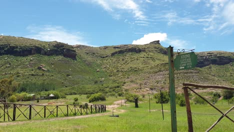 Old-gravel-road-leading-to-the-chalets-and-guest-houses-at-Camelroc-vacation-farm-past-old-trees-and-farm-fence,-South-Africa