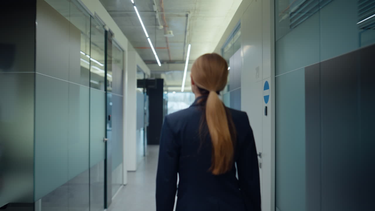 Confident employee stepping corridor back view. Blonde lady greeting colleague