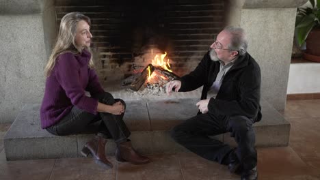 pareja de ancianos descansando cerca de la chimenea