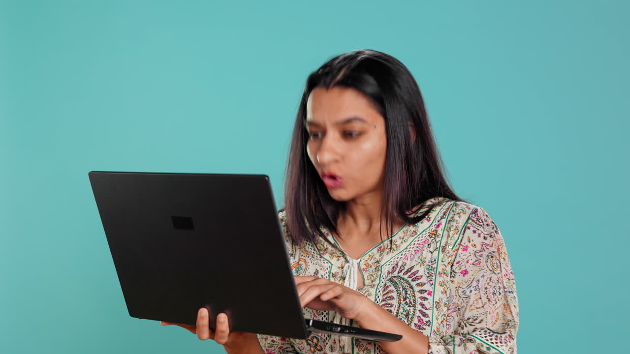 mujer escribiendo en el teclado de la computadora portátil y maldiciendo, sintiéndose enojada en el trabajo