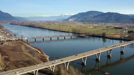 aerial view of mission bridge and railway bridge over the fraser river in mission, bc, canada - drone shot