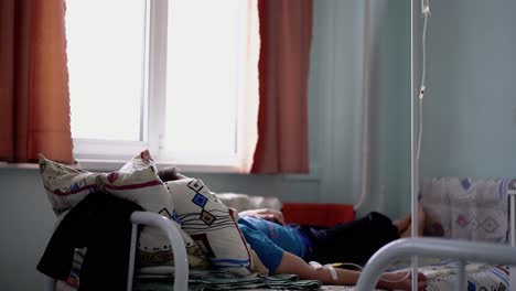 patient is in a hospital bed he is injected intravenously with medicine