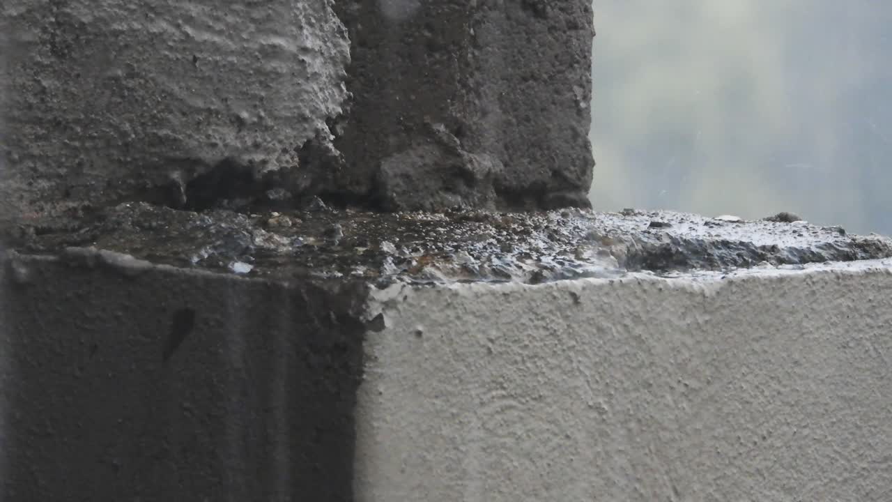 뇌우 동안 빗방울과 우박이 석고와 건물 벽돌에 떨어지고 떨어지는