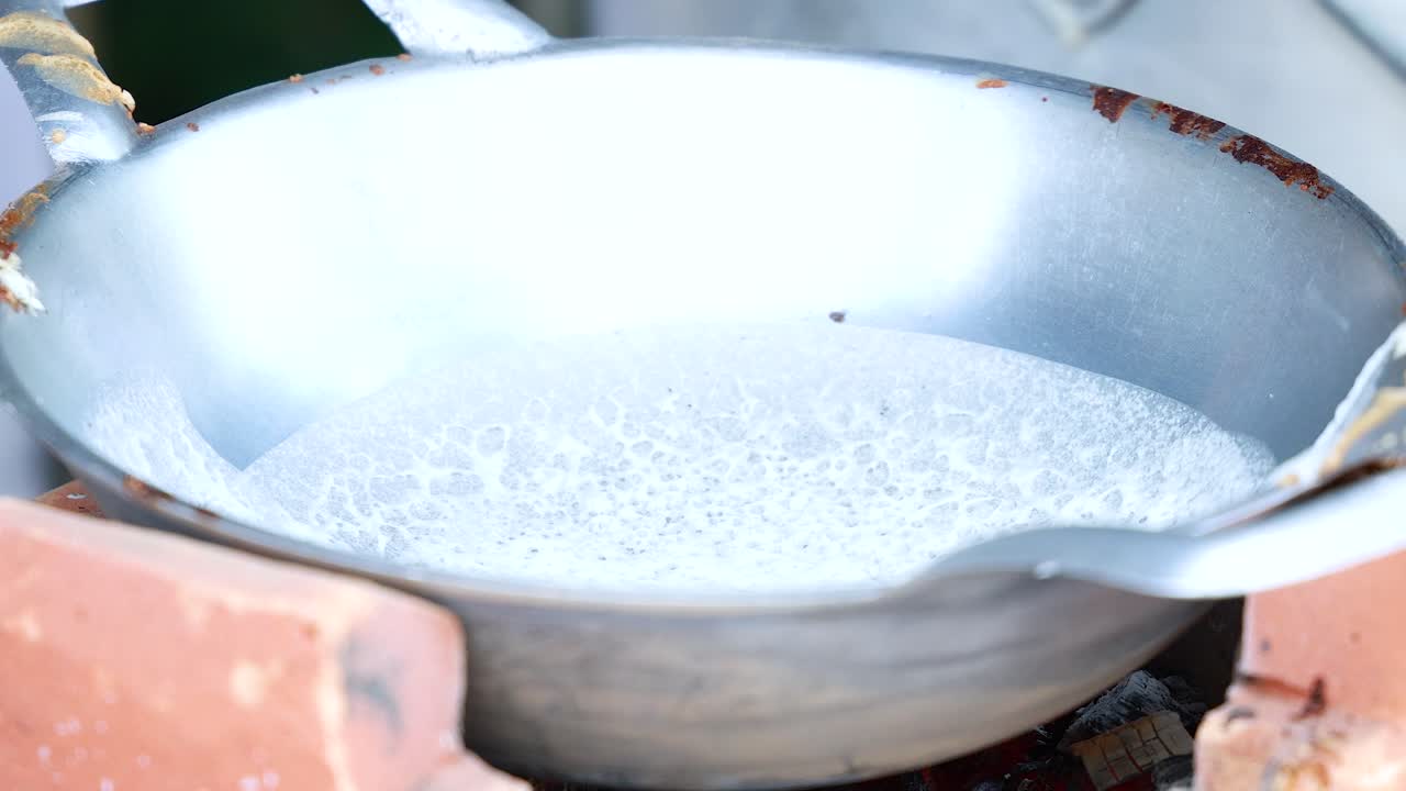 Miscela di cocco che bolle in una padella di metallo