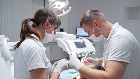 dentist takes the device from a dental drilling machine. stomatology professionals solving patient's dentistry problems.
