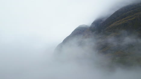 Foggy-mountains-in-Glencoe,-Scotland,-create-a-mystical-and-serene-atmosphere,-aerial-view