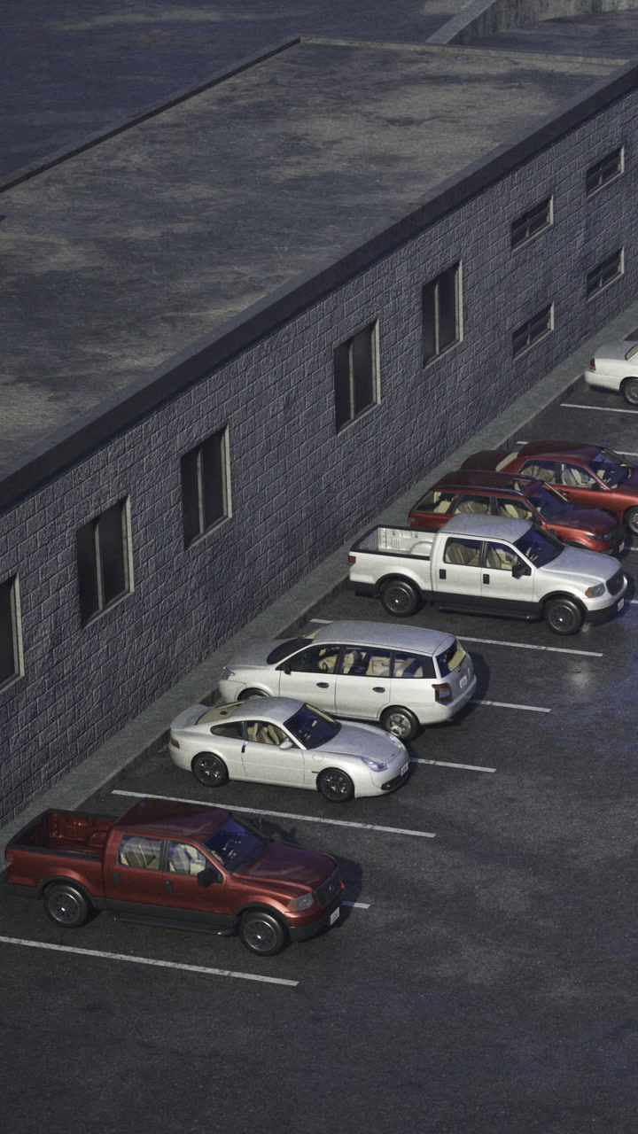 Parking lot filled with cars in front of a building during the day