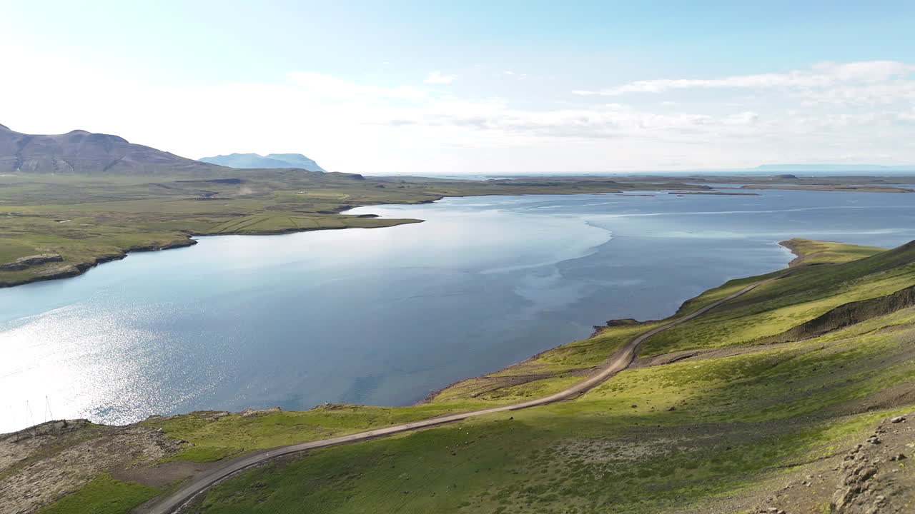 Aerial view of Hvammsfjörður in Vesturland Iceland on a colorful sunny day, showing vibrant waters, surrounding landscape, and clear blue sky from above