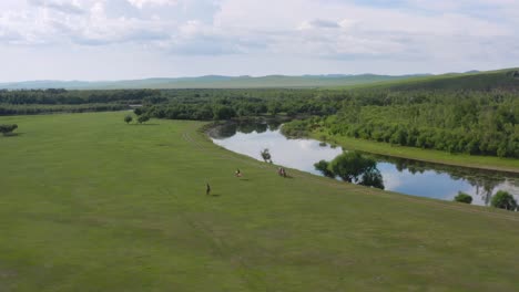 Group-of-people-riding-horses-on-Genheyuan-wetlands,-Mongolia