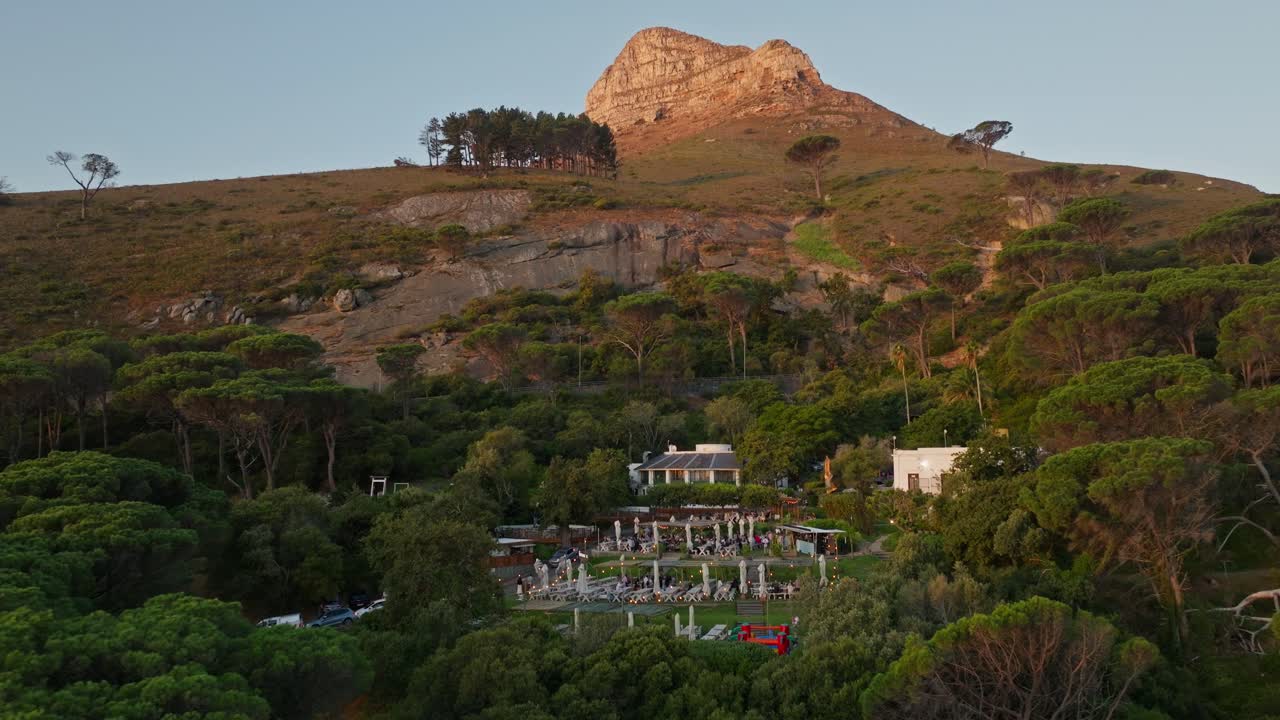 Drone shot of a beautiful restaurant at the foot of Lionshead during sunset.
