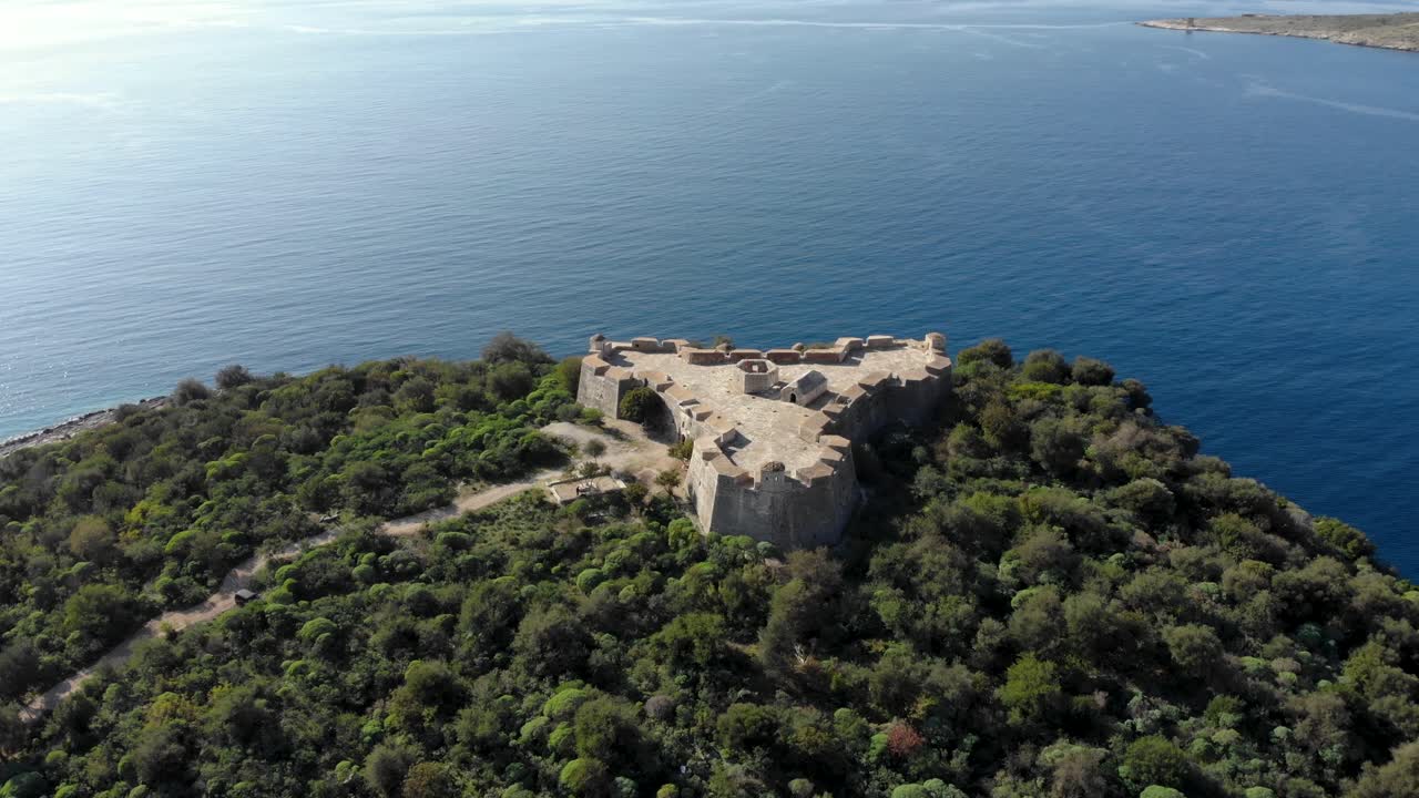 Fortezza in posizione strategica su un promontorio con vista mare, circondata da alberi verdi in Albania.