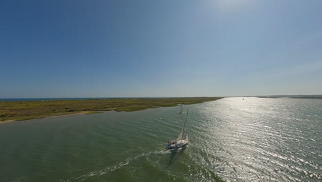 High-aerial-tracks-large-white-sailboat-sailing-fast-on-ocean-lagoon