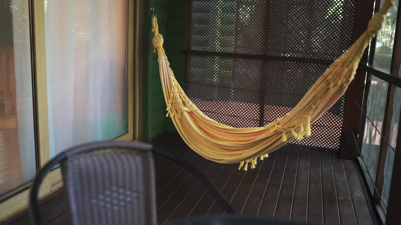Yellow hammock is hanging on the terrace of a vacation rental room in the jungle. Argentina.