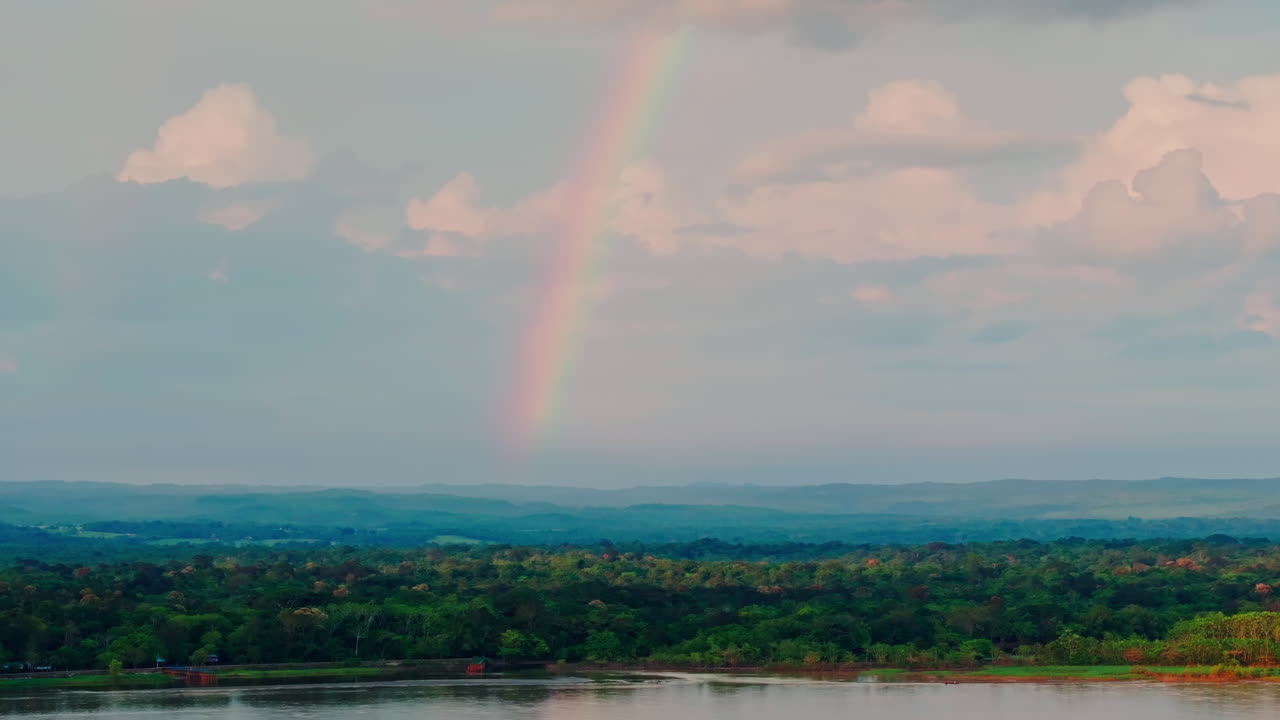 Pemandangan drone pelangi di atas hutan Amazon, menangkap cahaya warna-warni di atas kanopi tropis yang lebat dan keindahan alam yang luas dari lanskap hutan hujan