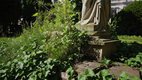 overgrown stone statue in a garden