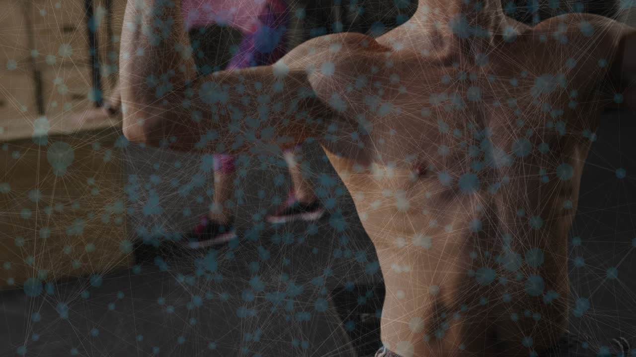 Shirtless man holding weights at shoulder pressing overhead for strength, gym mirror showing woman