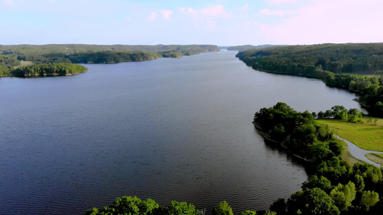 vista aérea de la madre naturaleza que muestra un río tranquilo corriendo en medio de un denso bosque verde en un día soleado