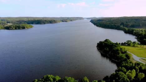 aerial view of mother nature showing calm river running in the middle of dense green forest on a bright sunny day