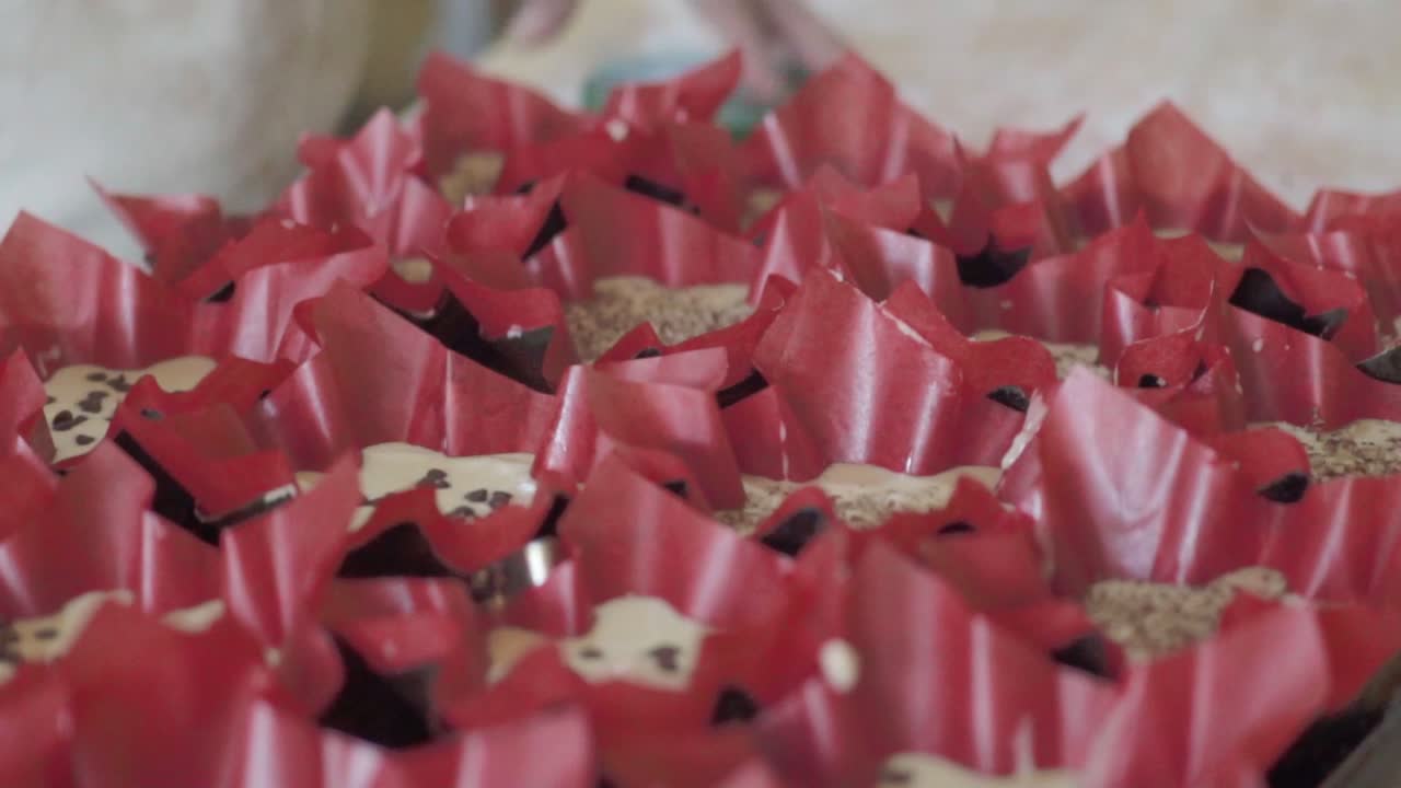 베이킹 을 위해 컵케이크 라인 에 반죽 을 부는 페이스트리 셰프 의 클로즈업